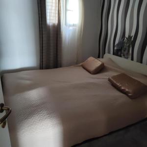 a bed with two pillows on it in a bedroom at Cosy apartman Split - in green area in Solin +13 photos