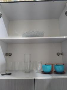 three bowls sitting on a shelf in a kitchen at Apartamento da mel in Águas de Lindóia +12 photos