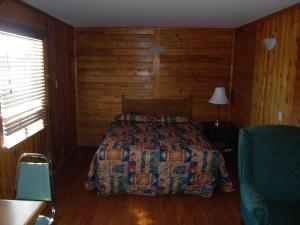 a bedroom with a bed and a wooden wall at Virden Motel in Virden