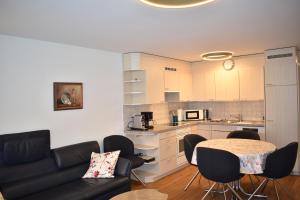 a living room with a couch and a table and a kitchen at Sotmirana 53 (316 Sh) in Lenzerheide