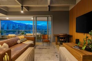een woonkamer met een bank en een flatscreen-tv bij Life 1603 - Panoramic & Tastefully Decorated Loft in El Poblado