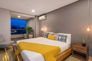 een slaapkamer met een groot bed met een gele deken bij Life 1603 - Panoramic & Tastefully Decorated Loft in El Poblado +17 foto's