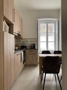 センテンドレにあるPatak & Stone apartmanのテーブルと椅子と窓のあるキッチン