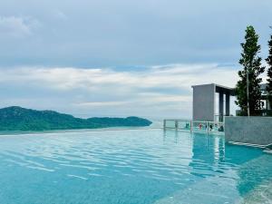 a swimming pool with a view of the water at Sky Pool Luxury Sea View Near Penang Airport 9pax in Bayan Lepas
