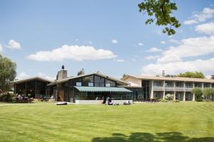 a large building with a grass field in front of it at Wanaka Hotel in Wanaka