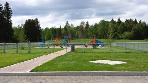 a park with a playground with slides and swings at Les appartement 4 saisons des iles in Saint-Gédéon