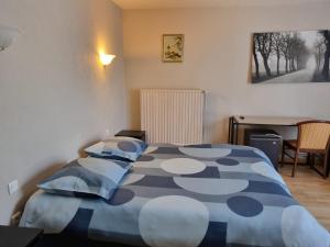 a blue and white bed in a room with a desk at Auberge de la Forêt in Le Nouvion-en-Thiérache +28 photos