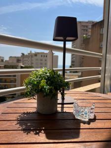 ボーソレイユにあるNew Large Studio - Monaco Border - Sea View - Lift - Parking includedのランプとグラスが置かれたテーブルの上の植物