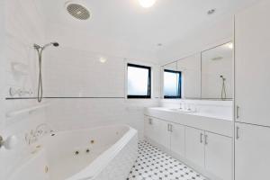 un bagno bianco con vasca e 2 lavandini di Inverloch Dual Retreat with Spa Bath 400m to Beach a Inverloch Altre 42 foto