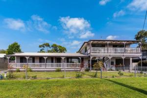 una casa con un ampio portico e balcone di Inverloch Dual Retreat with Spa Bath 400m to Beach a Inverloch