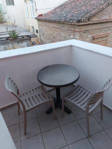 a table and two chairs sitting on a balcony at ATHENA'S Central APP in Samos +6 photos