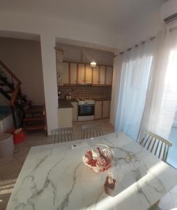 a kitchen with a table with a bowl of flowers on it at ATHENA'S Central APP in Samos