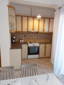 a kitchen with wooden cabinets and a stove top oven at ATHENA'S Central APP in Samos