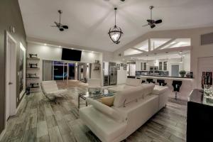 a living room with a white couch and a kitchen at Villa Camelot - Gulf Access in Shell Point Village