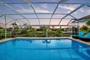 a swimming pool with a glass roof over it at Villa Camelot - Gulf Access in Shell Point Village