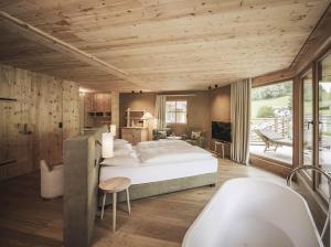 a bedroom with a large bed and a bath tub at Naturhotel Lüsnerhof in Luson +52 photos