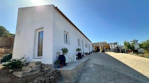 a white building with plants on the side of it at Yoga Farm in Tavira