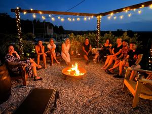 a group of people sitting around a fire in a yard at Private Pool & Sun Terrace Pet Friendly Holiday Home in Grabovnica +18 photos