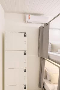 a room with two beds and a refrigerator at Hospedaria Colonial - Pousada e Hostel in São Luís