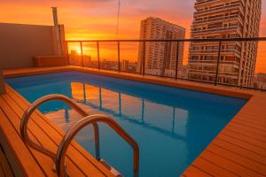 布宜诺斯艾利斯Modern Apartments in Palermo - by BueRentals的日落时分，建筑屋顶上的游泳池