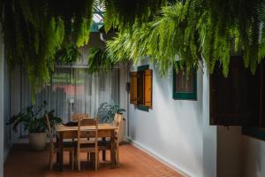 a table and chairs in a room with plants at Estância Boi Sentado in Santa Rita do Passa Quatro