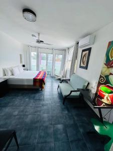 a bedroom with a bed and a couch and chairs at The Quetzal in Cancún
