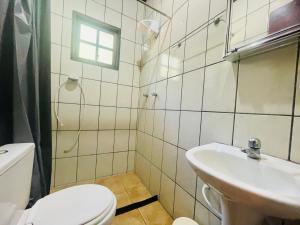 a bathroom with a toilet and a sink at Pousada Nascente da Pedra in Pedra Bela