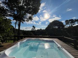 a hot tub with a view of the trees at Pousada Nascente da Pedra in Pedra Bela
