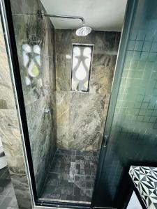 a shower with a glass door in a bathroom at The Quetzal in Cancún