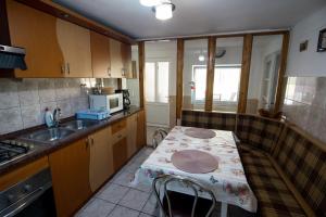 Una pequeña cocina con una mesa y un fregadero. en Casa Sara, en Sighişoara