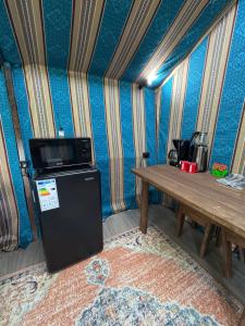 a small refrigerator and a table in a room at Turgen Family Park in Taūtürgen +12 photos