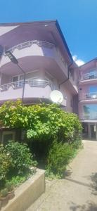 a large building with bushes in front of it at Villa Bardha in Struga +8 photos