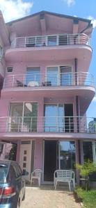 a pink building with two benches in front of it at Villa Bardha in Struga