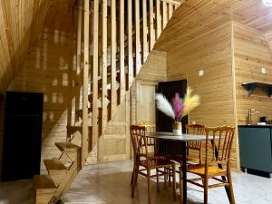 a dining room with a table and chairs and a staircase at Panorama cottage Martvili in Martvili