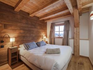 a bedroom with a bed with wooden walls and a window at Maison rénovée familiale au village - FR-1-808-19 in Le Monêtier-les-Bains