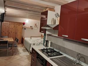 a kitchen with a stove top oven next to a bed at Casa Anelis in Bedollo