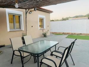 a glass table and chairs on a patio at Seagull House Thassos island in Skala Kallirachis