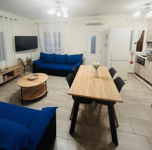 a living room with a table and a blue couch at Seagull House Thassos island in Skala Kallirachis
