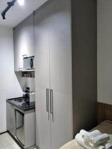 eine Küche mit einem weißen Schrank und einer Mikrowelle in der Unterkunft Flat em frente ao Allianz Park in São Paulo