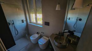 a bathroom with two sinks and a toilet and a mirror at Suite Posillipo 298 in Naples +8 photos