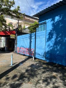 a blue wall with a gate in front of a building at Kitnet no centro de Manaus in Manaus +1 photo