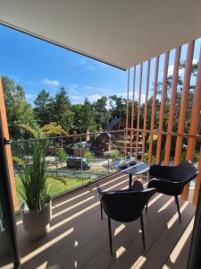 un balcone con due sedie e un tavolo di Apartamenty PINEA tuż przy plaży a Pobierowo