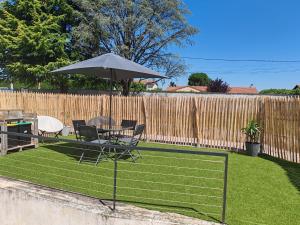 a patio with a table and chairs and an umbrella at La Cigaline in Anneyron