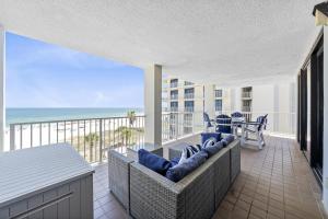a living room with a couch and a balcony with the ocean at Pelican Pointe 506 in Orange Beach