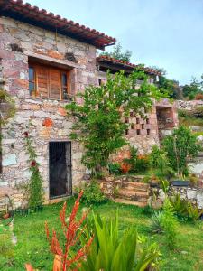 a stone house with a garden in front of it at Casa de Cristal - Vila de Igatu in Andaraí +10 photos