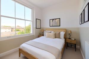 a bedroom with a bed and a large window at The Camden Hideout - Modish and Bright 2BDR Flat in London