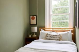 a bedroom with a bed with a window at The Camden Hideout - Modish and Bright 2BDR Flat in London