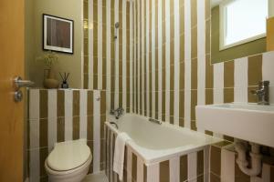 a bathroom with a white toilet and a sink at The Camden Hideout - Modish and Bright 2BDR Flat in London