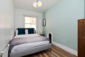 Un dormitorio con una cama y una chimenea. en The South Kensington Mews - Lovely 5BDR Home, en Londres