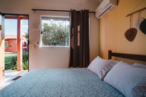 a bedroom with a bed and a window at Pousada Sertão in Alto Paraíso de Goiás